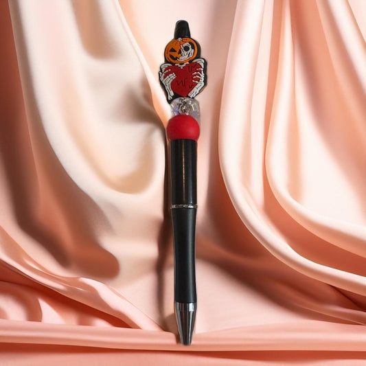 Black beaded pen with pumpkin heart charm and red accent beads, handmade Halloween writing accessory.