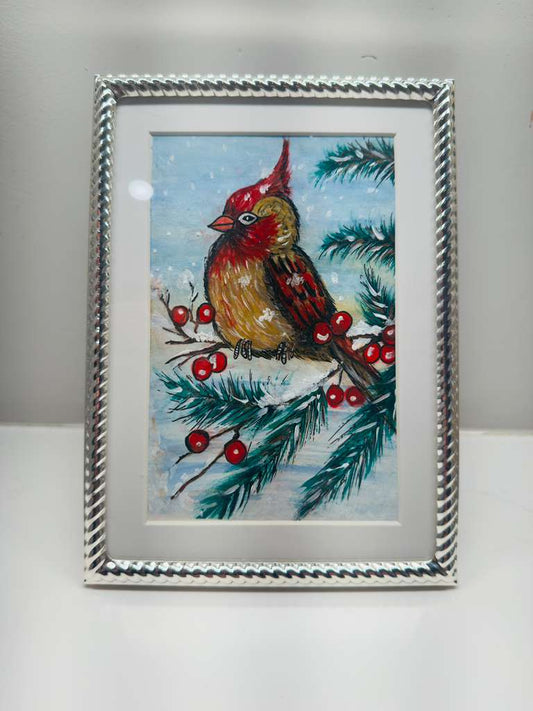 Framed artwork of a bird on a branch with berries and snowflakes.