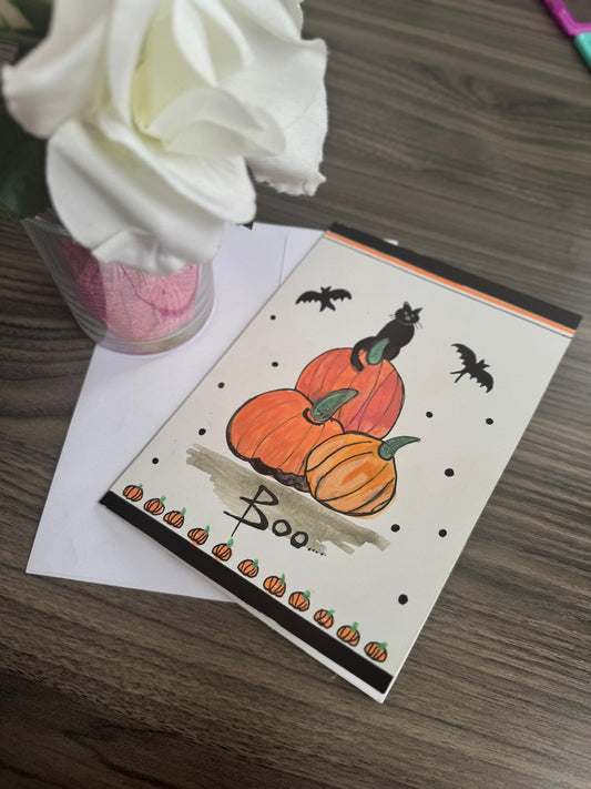 Handmade Halloween card with black cat on pumpkins, bats flying, and Boo text – blank inside with envelope.
