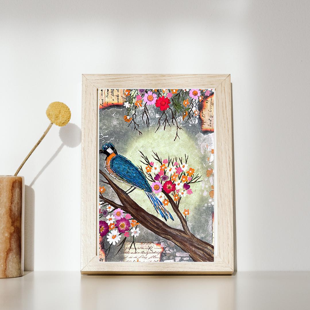 Handmade artwork of a blue bird on a branch with flowers against a light background