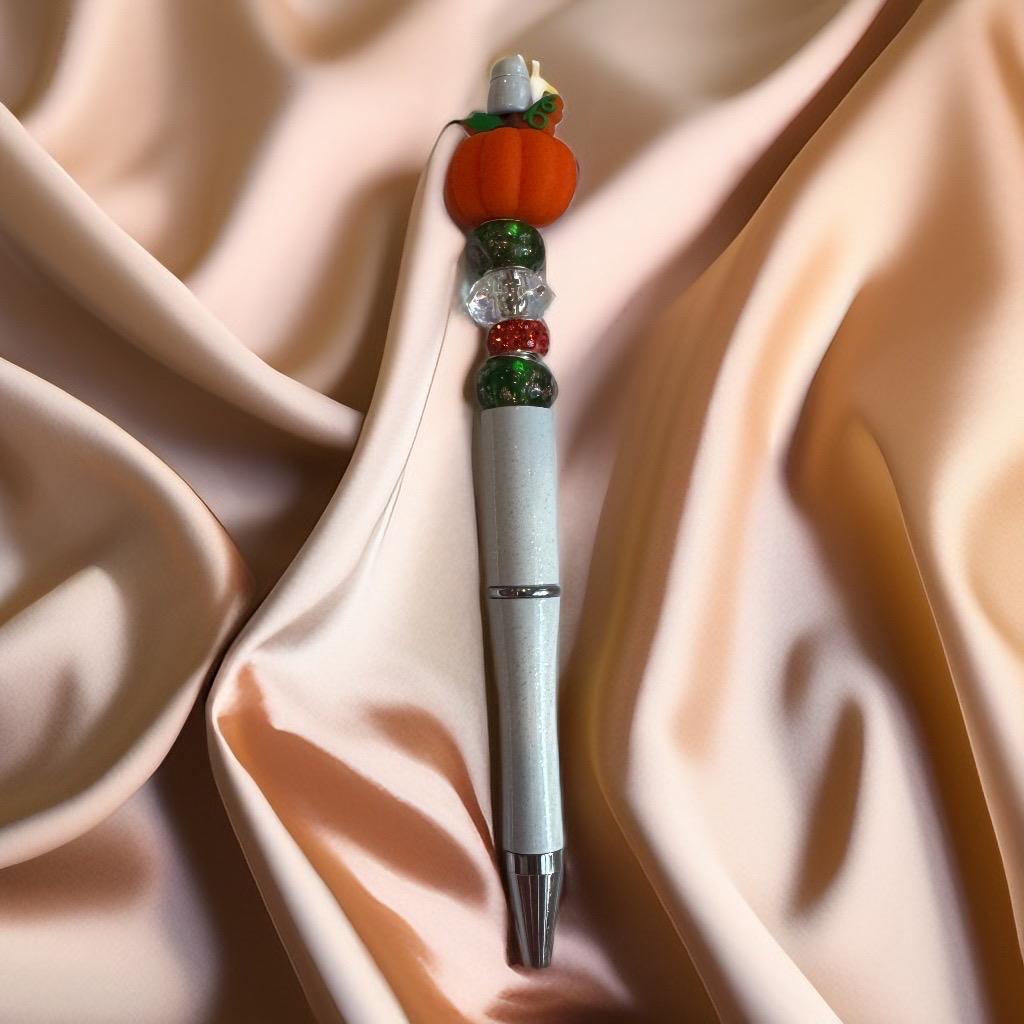 White pen with orange pumpkin charm and sparkling green and red beads, handcrafted festive Halloween pen.