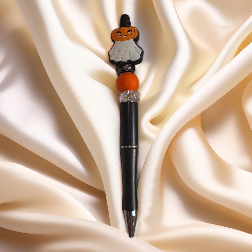 Black pen topped with pumpkin ghost charm and orange beads, handmade Halloween beaded pen.