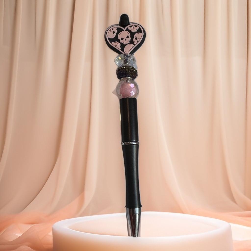 Black pen with pink skull heart charm and glitter beads, spooky-chic handmade Halloween pen.