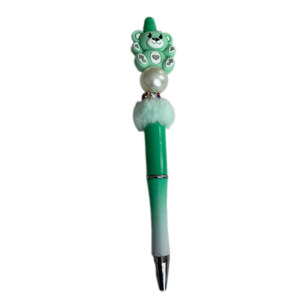Handmade green beaded pen with cute bear character topper, pearl bead accent, and green ballpoint pen body.