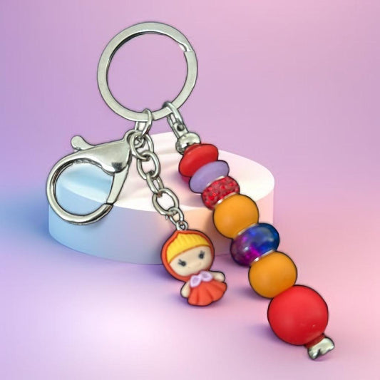 "Handmade Vibrant Beaded Keychain with Cute Doll Charm – Red & Orange Accent"