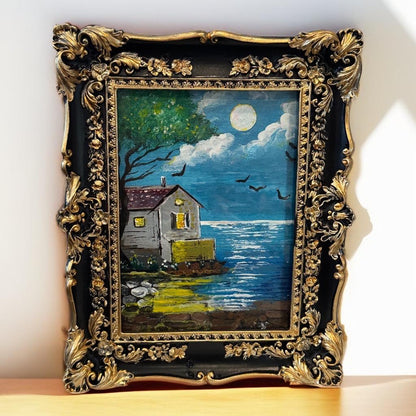 Moonlit Reflections framed painting – moonlit cottage by water with birds and tree in ornate golden frame
