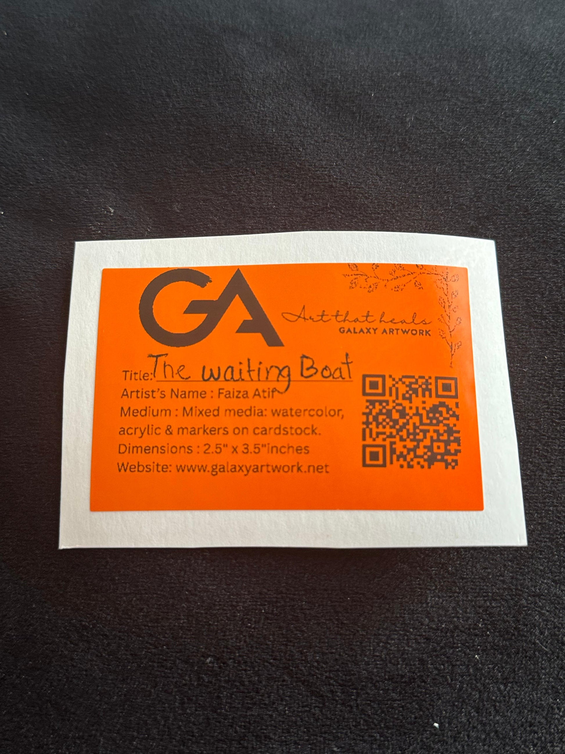 Orange and white label with text and a QR code on a black background