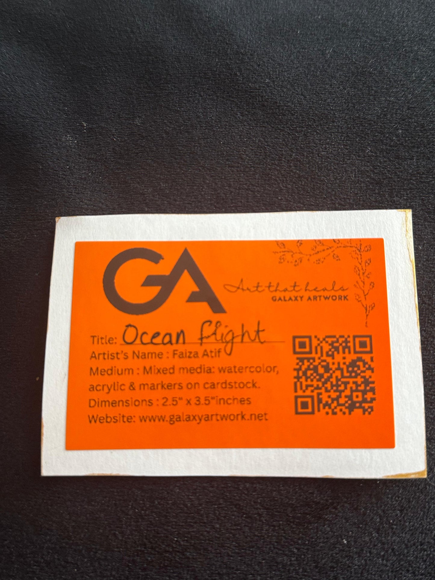 Silhouette of a dolphin leaping out of the ocean against a glowing orange and yellow sunset.