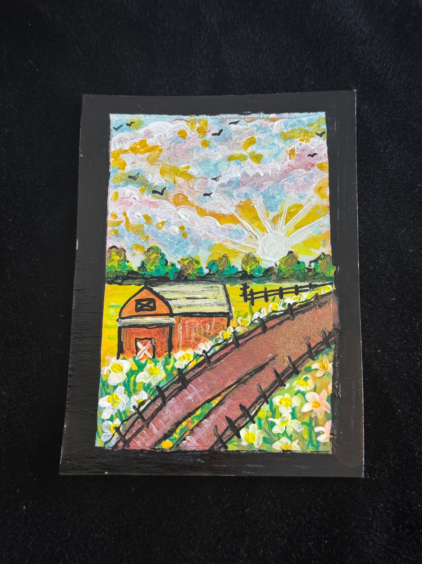 Colorful painting of a barn and landscape on a black background