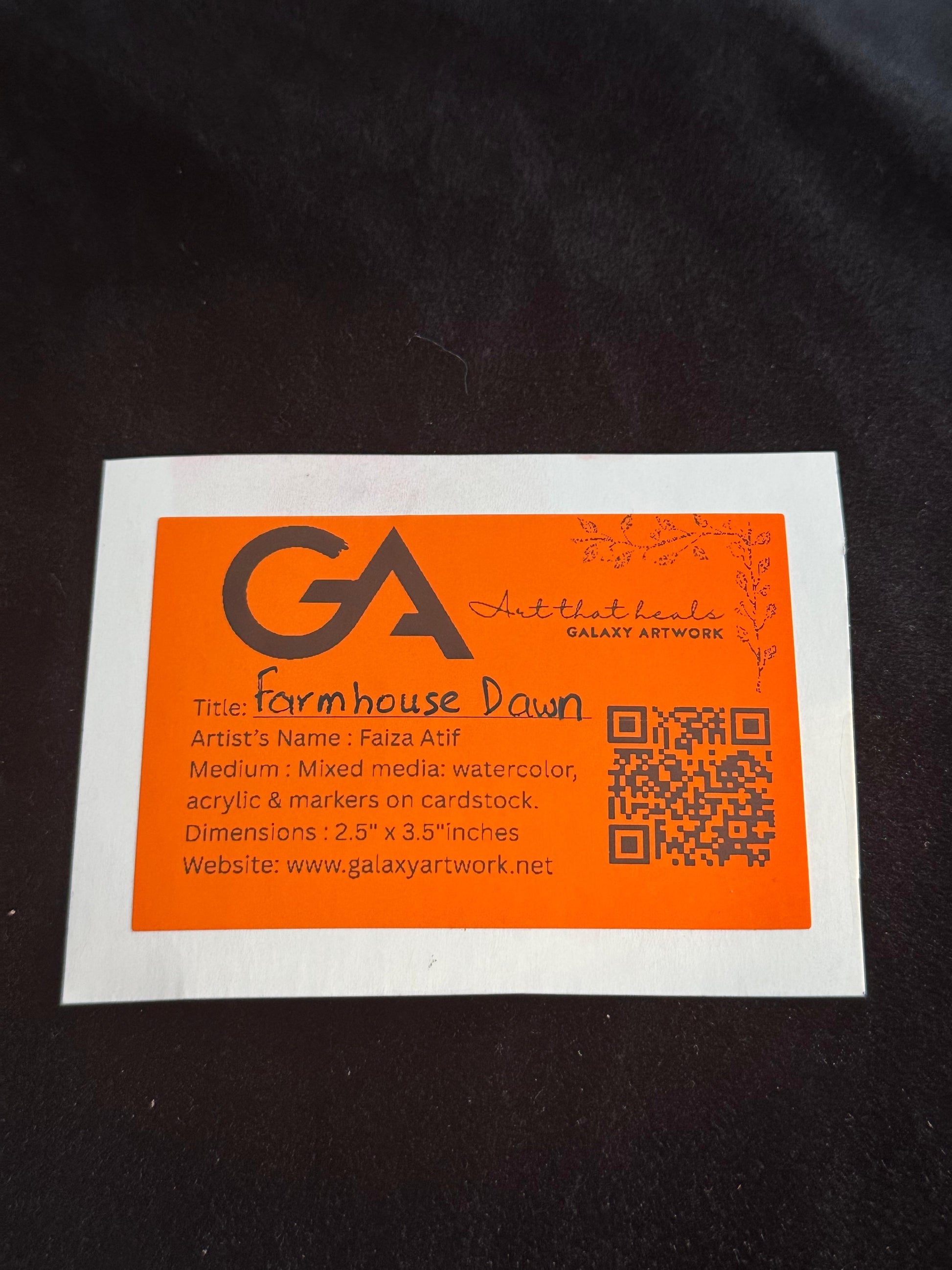 Orange and white label with text and QR code on a dark background