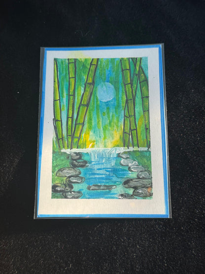 ACEO art card of a moonlit bamboo grove with a flowing waterfall and reflective blue water surrounded by stones.