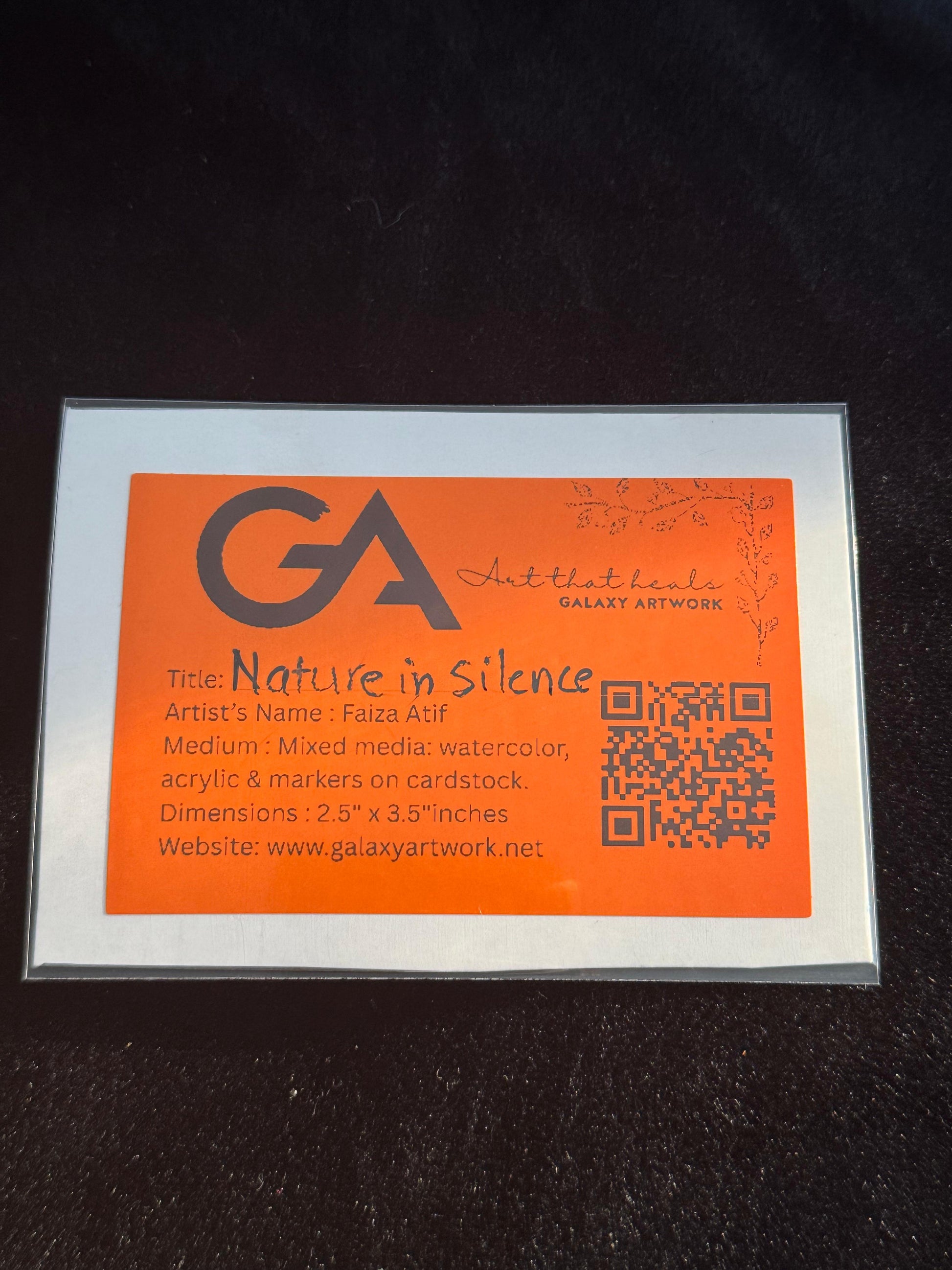 Artwork card with orange background and black text on a dark surface