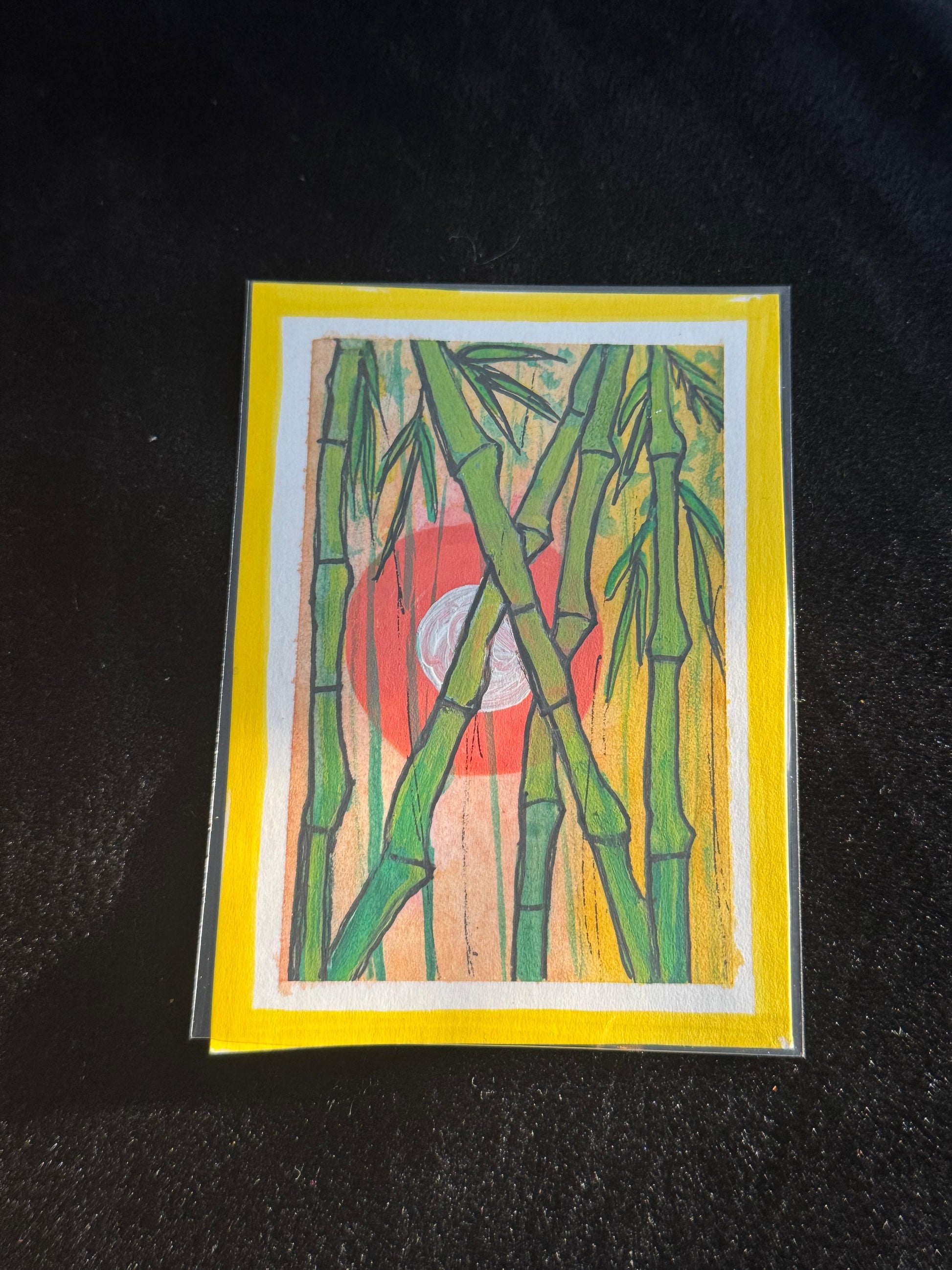 Hand-painted ACEO card of green bamboo stalks with a glowing white moon rising against a vivid red sunset background.”