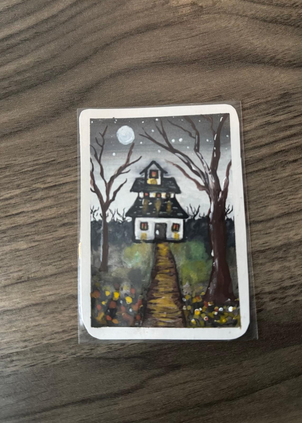 ACEO card of a haunted house with a moonlit sky .