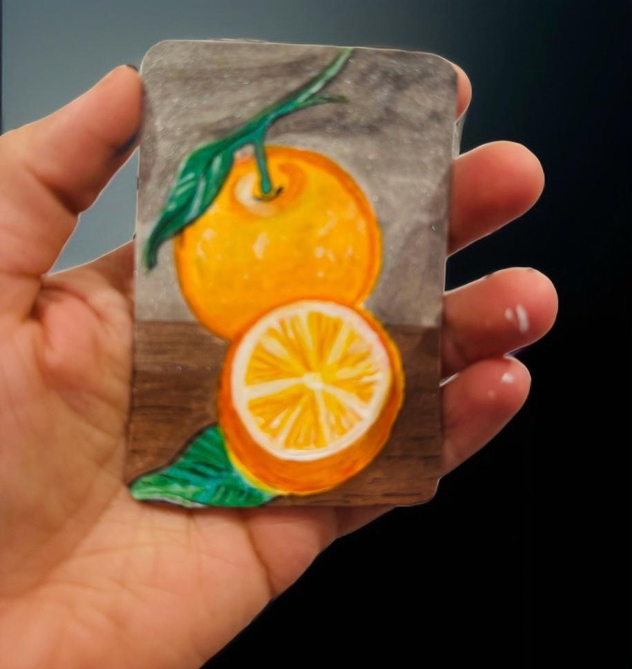 Hand-painted ACEO card of orange with slice and leaves on rustic table.