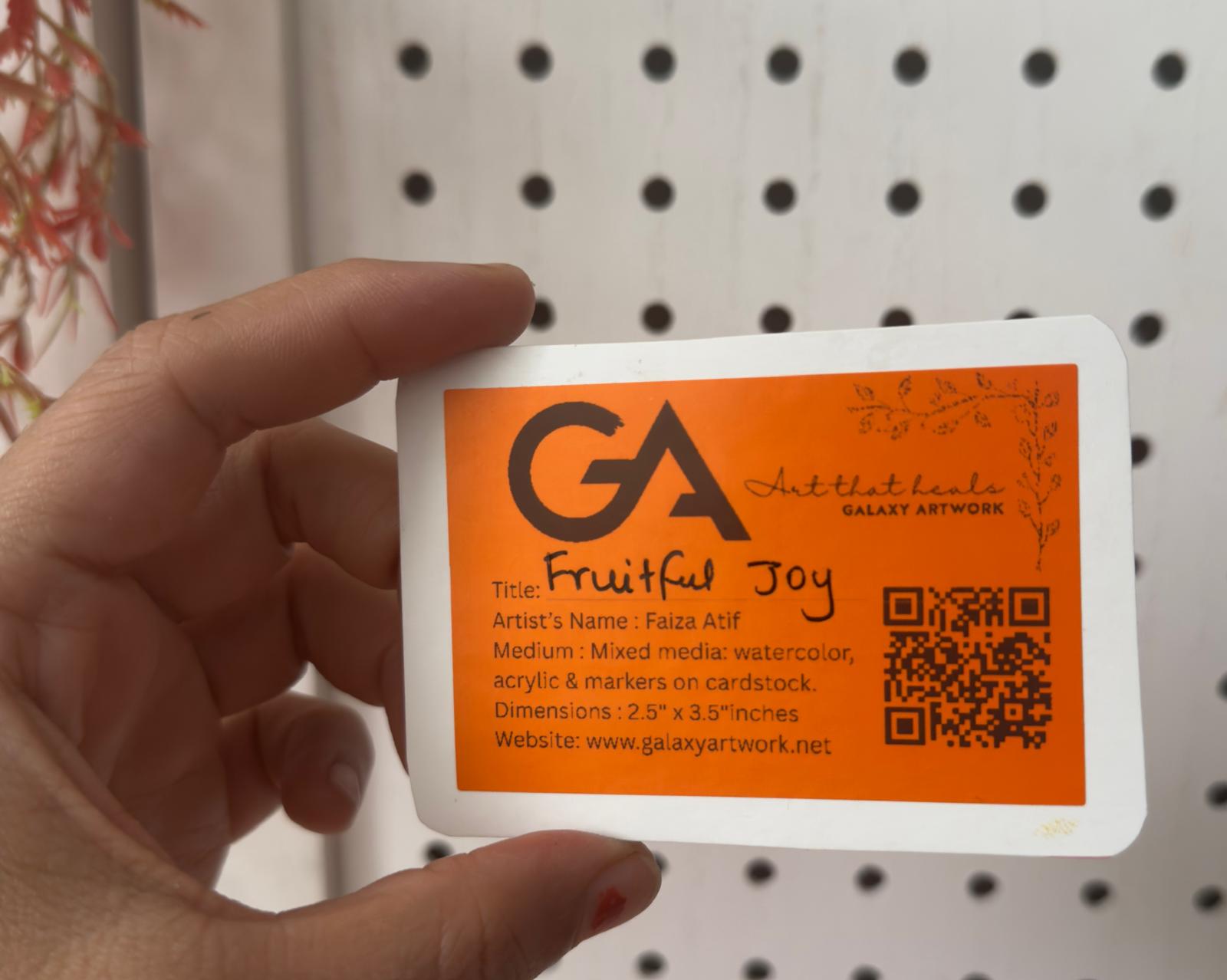 Hand holding a business card with 'GA' logo and text on an orange background.