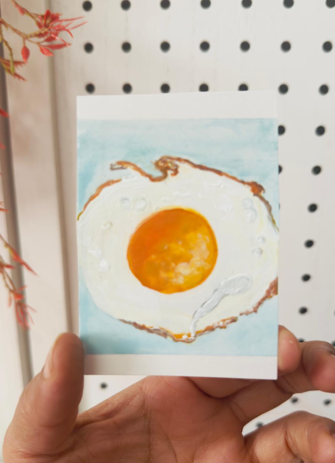 Hand-painted ACEO card of sunny side up fried egg with textured detail.