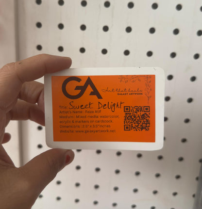 Hand holding a card with 'GA Art Gallery' branding against a pegboard background