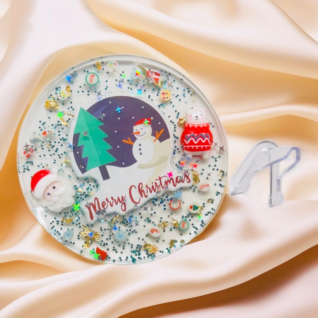 Handmade December Christmas resin coaster with Santa and snowman, clear round glitter holiday decor.