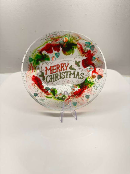 Decorative Christmas plate with a wreath design and 'Merry Christmas' text on a white background.
