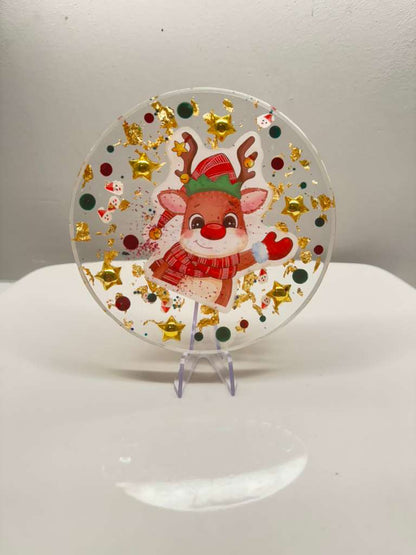 “Round clear resin Christmas coaster with cute reindeer design, gold stars and festive confetti glitter holiday décor.
