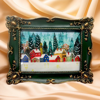 Decorative green and gold frame with a Orignal painting of winter village scene  .