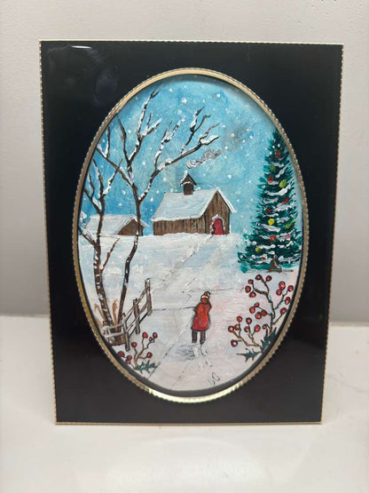 Winter scene with a house, tree, and person in a red coat on a black border