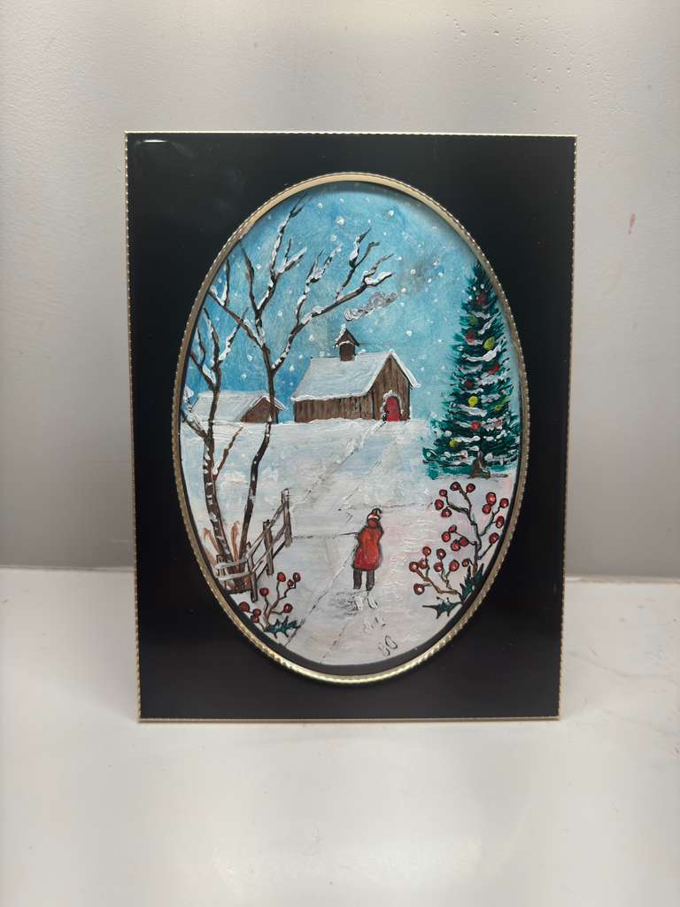 Winter scene with a barn, trees, and a person in a red coat on a snowy path, framed in black.