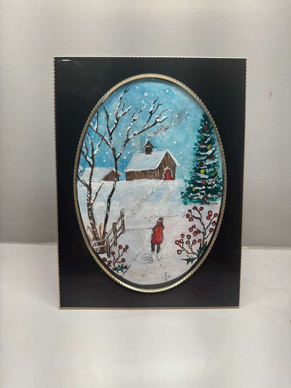 Winter scene with a barn, trees, and a person in a red coat on a snowy path, framed in black.