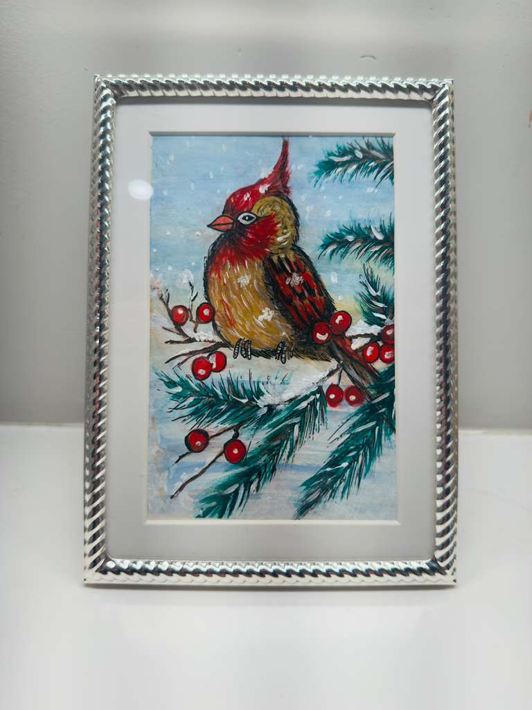 Framed artwork of a bird on a branch with berries and snowflakes.