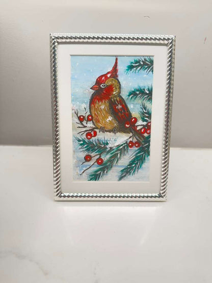 Handcrafted Christmas wall art showing a red cardinal perched on a snowy branch, framed and ready to display.