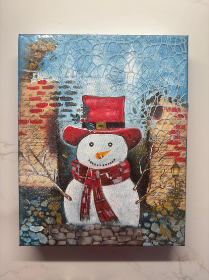 Handmade acrylic painting of a snowman wearing a red hat and scarf with a textured winter brick background.