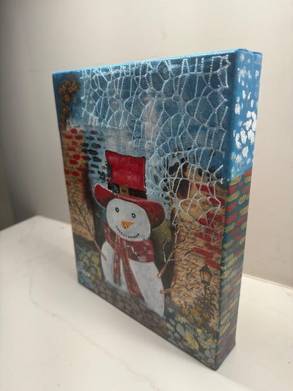 Handmade acrylic painting of a snowman wearing a red hat and scarf with a textured winter brick background.