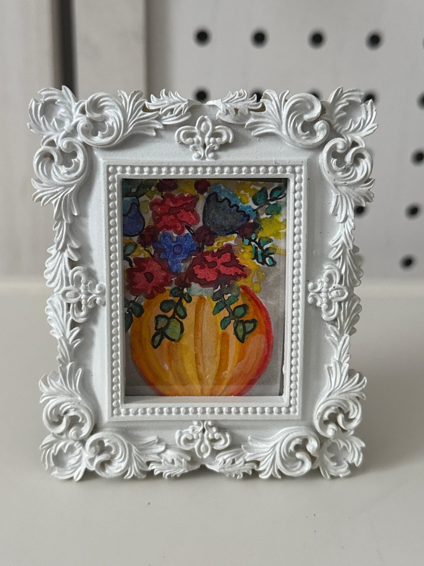 Decorative white frame with a colorful painting of flowers on a plain background