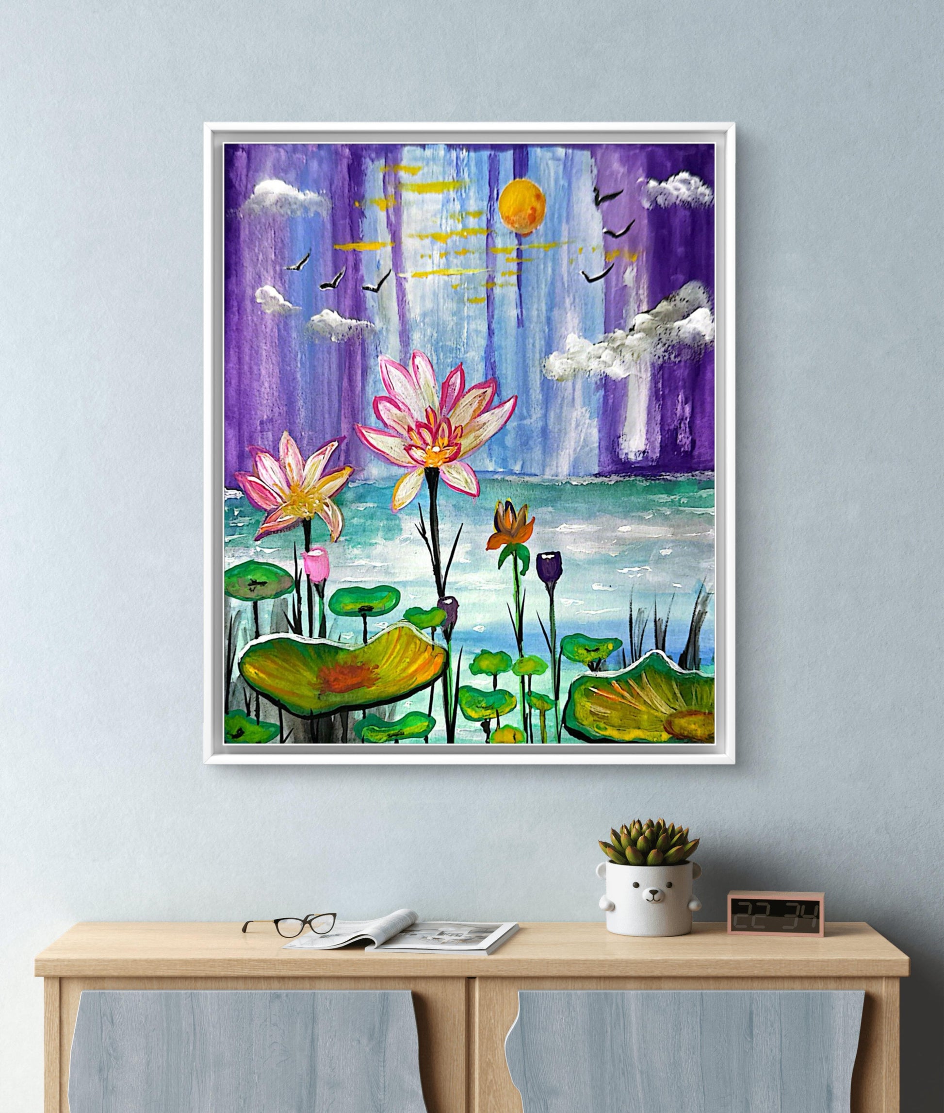 Framed artwork of lotus flowers and a purple sky with sun and clouds.