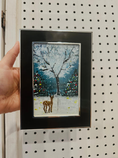 Framed artwork of a deer in a snowy landscape with trees. Handmade art.