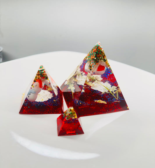 Triangular resin pieces with embedded snowmen.
