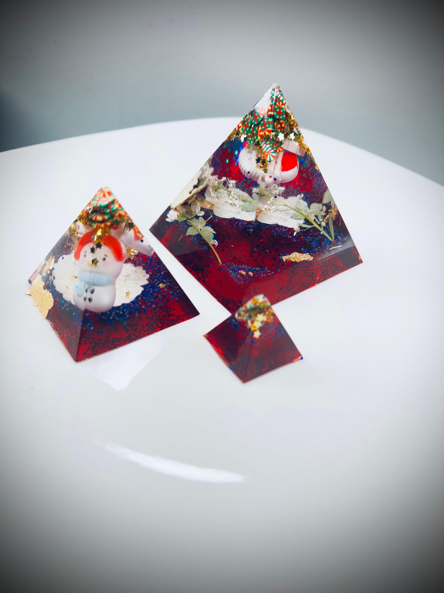 Triangular resin pieces with embedded snowmen.
