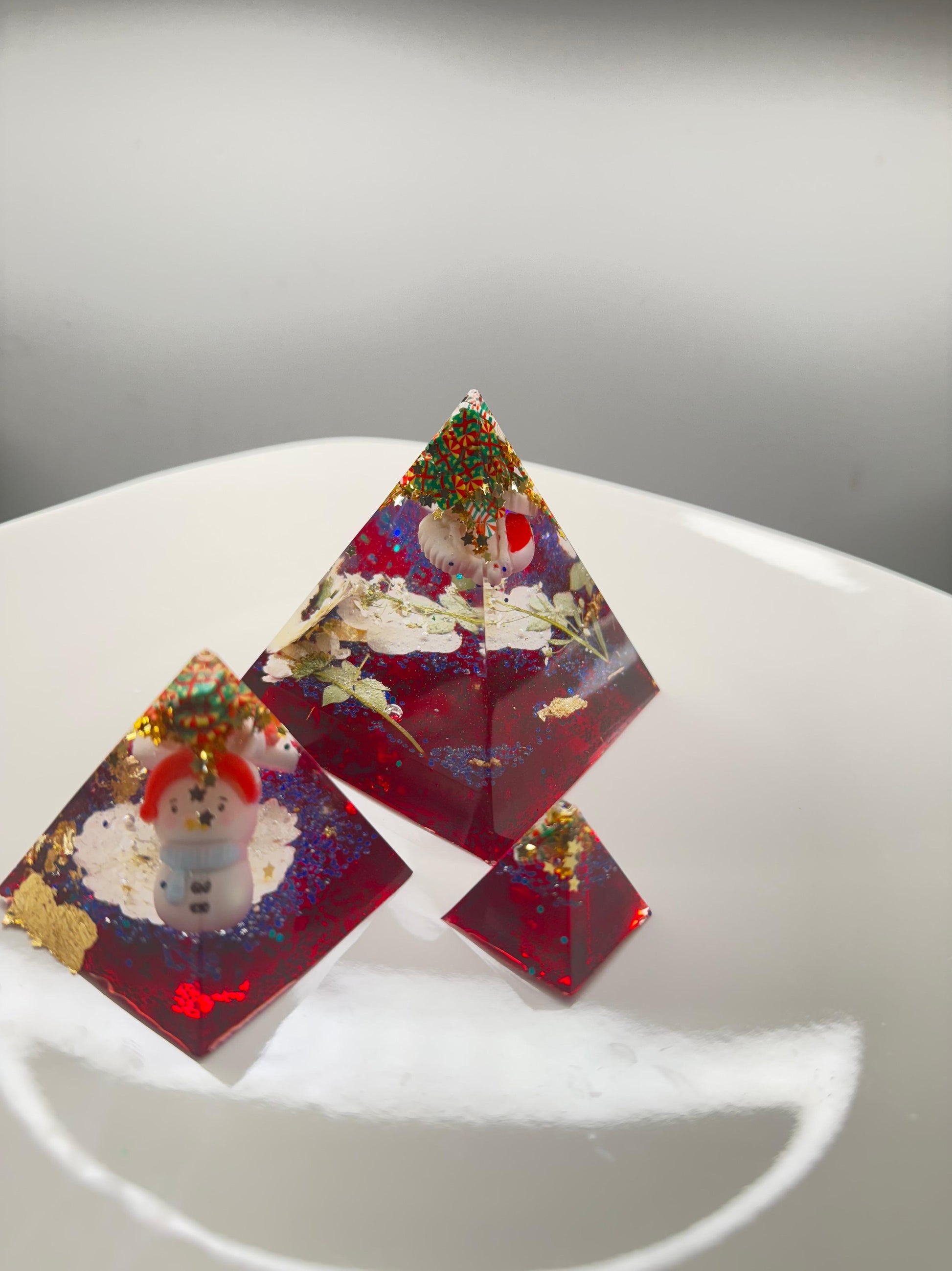 Triangular resin pieces with embedded snowmen.