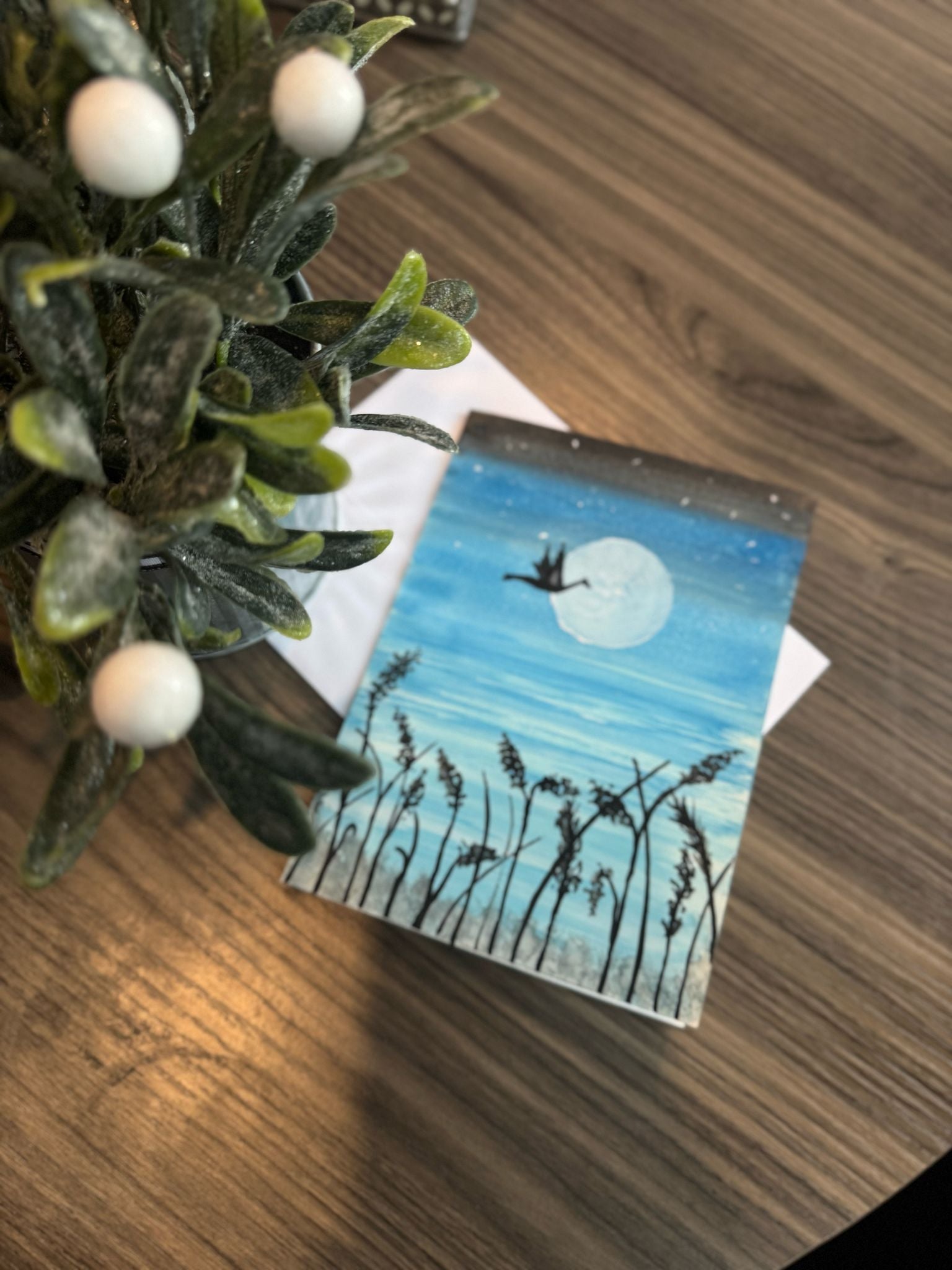Card with a nature design featuring a bird over water and moon