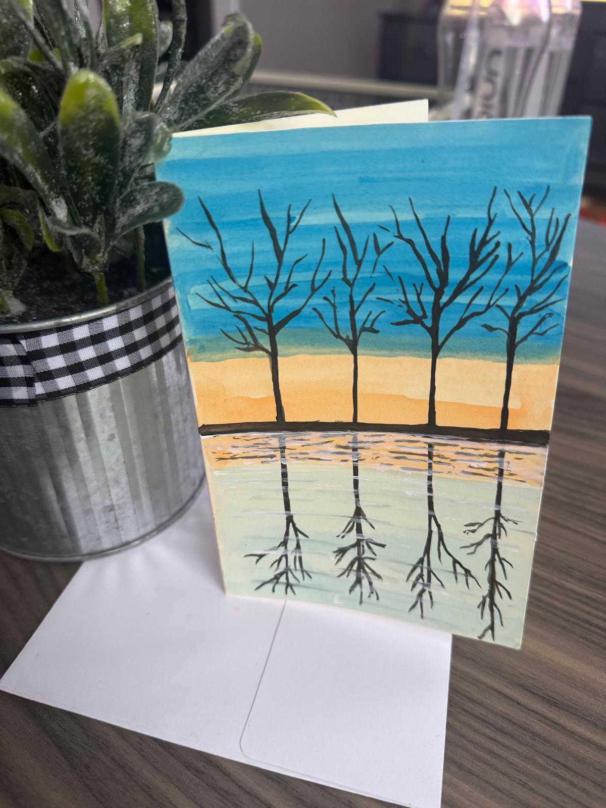 Greeting card with a nature scene of trees reflected in water 
