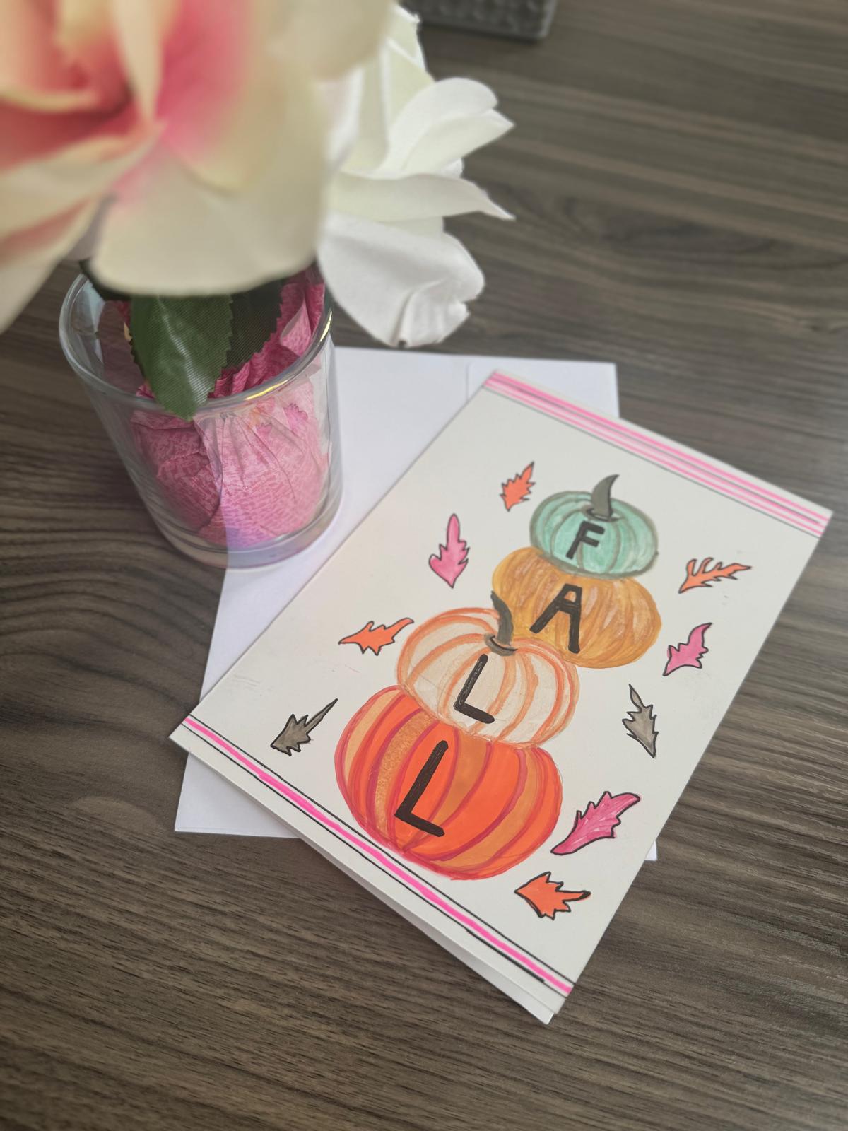 Hand-painted greeting card with stacked pumpkins and autumn leaves spelling FALL – blank inside with envelope.