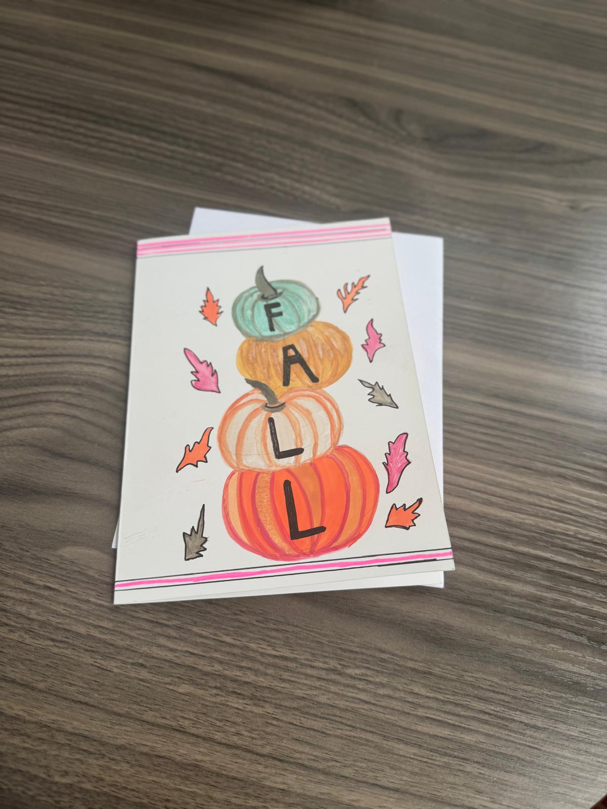 Hand-painted greeting card with stacked pumpkins and autumn leaves spelling FALL – blank inside with envelope.