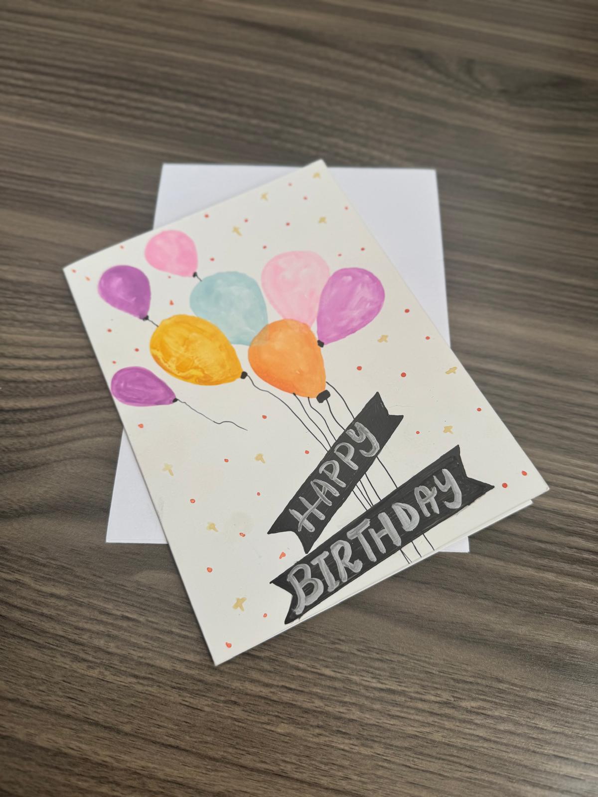 Birthday card with colorful balloons and 'Happy Birthday' text.