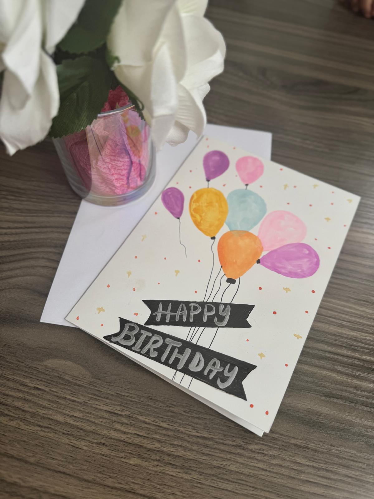 Hand painted Birthday card with balloons and 'Happy Birthday' text .