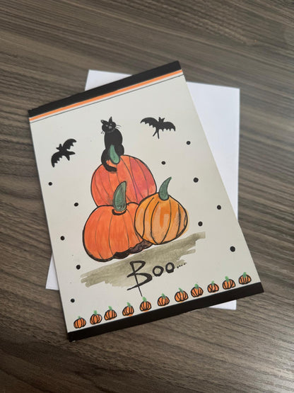 Handmade Halloween card with black cat on pumpkins, bats flying, and Boo text – blank inside with envelope.