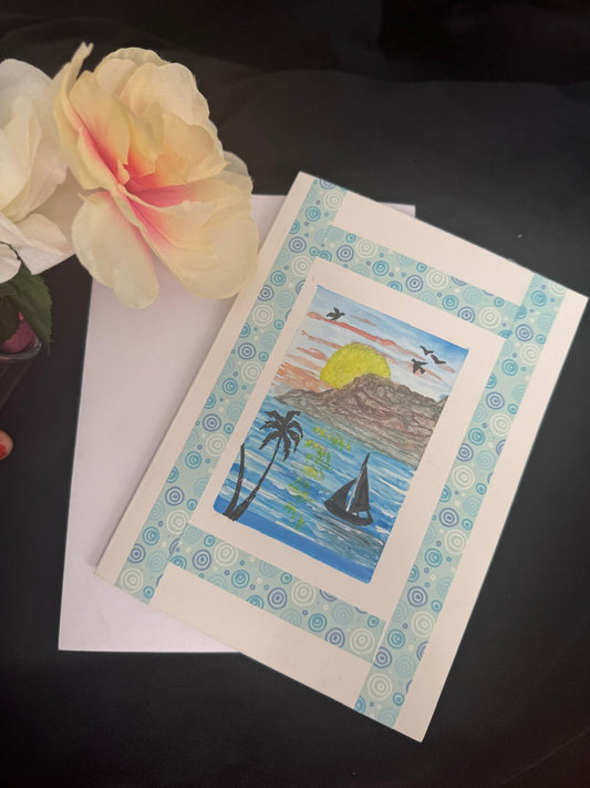 Handmade greeting card with palm trees, sailboat, and sunset over the ocean, blank inside with envelope