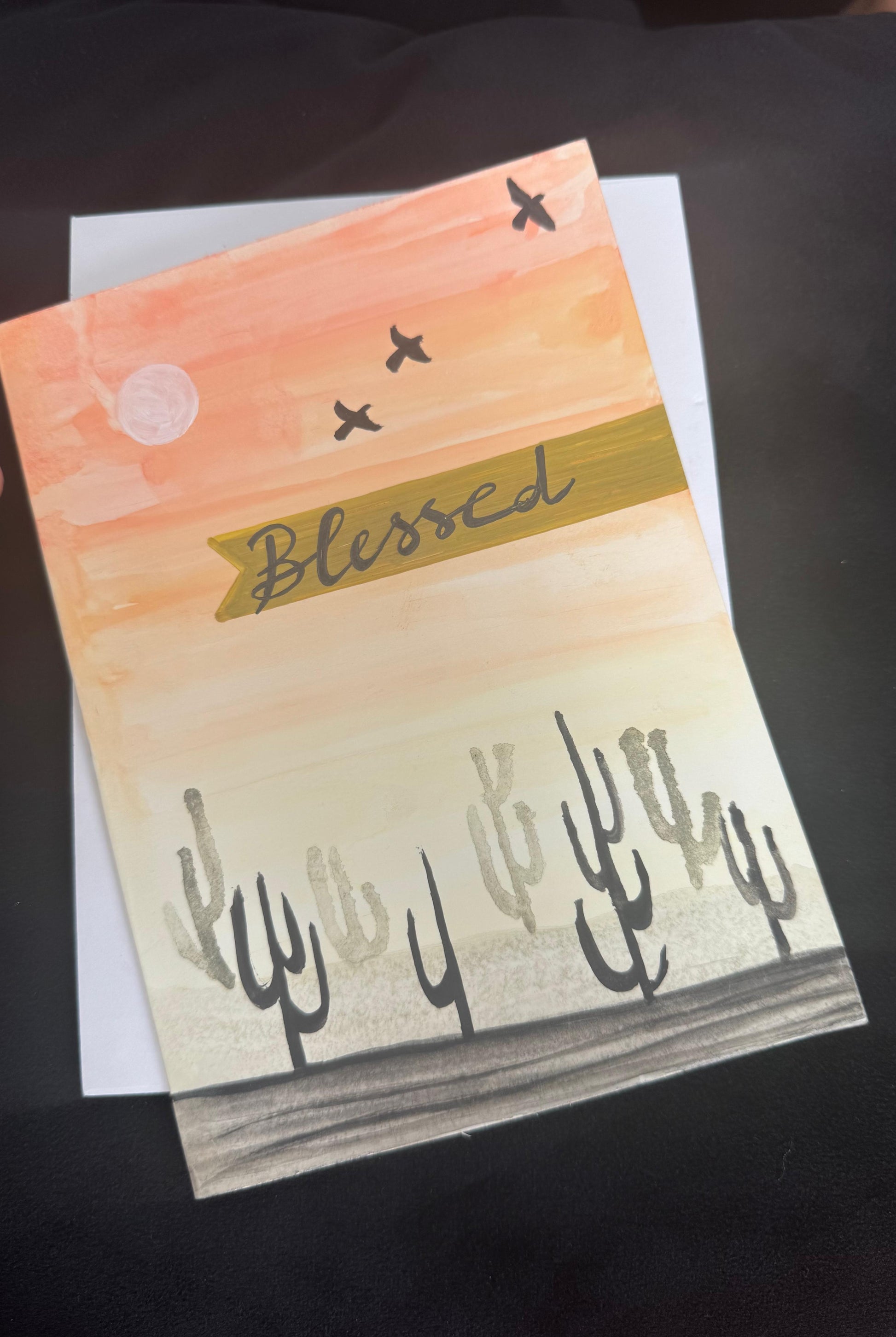 Hand-painted greeting card with desert sunset, cactus silhouettes, and Blessed message – blank inside with envelope.