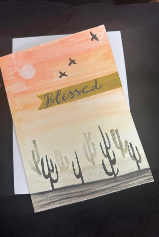 Hand-painted greeting card with desert sunset, cactus silhouettes, and Blessed message – blank inside with envelope.