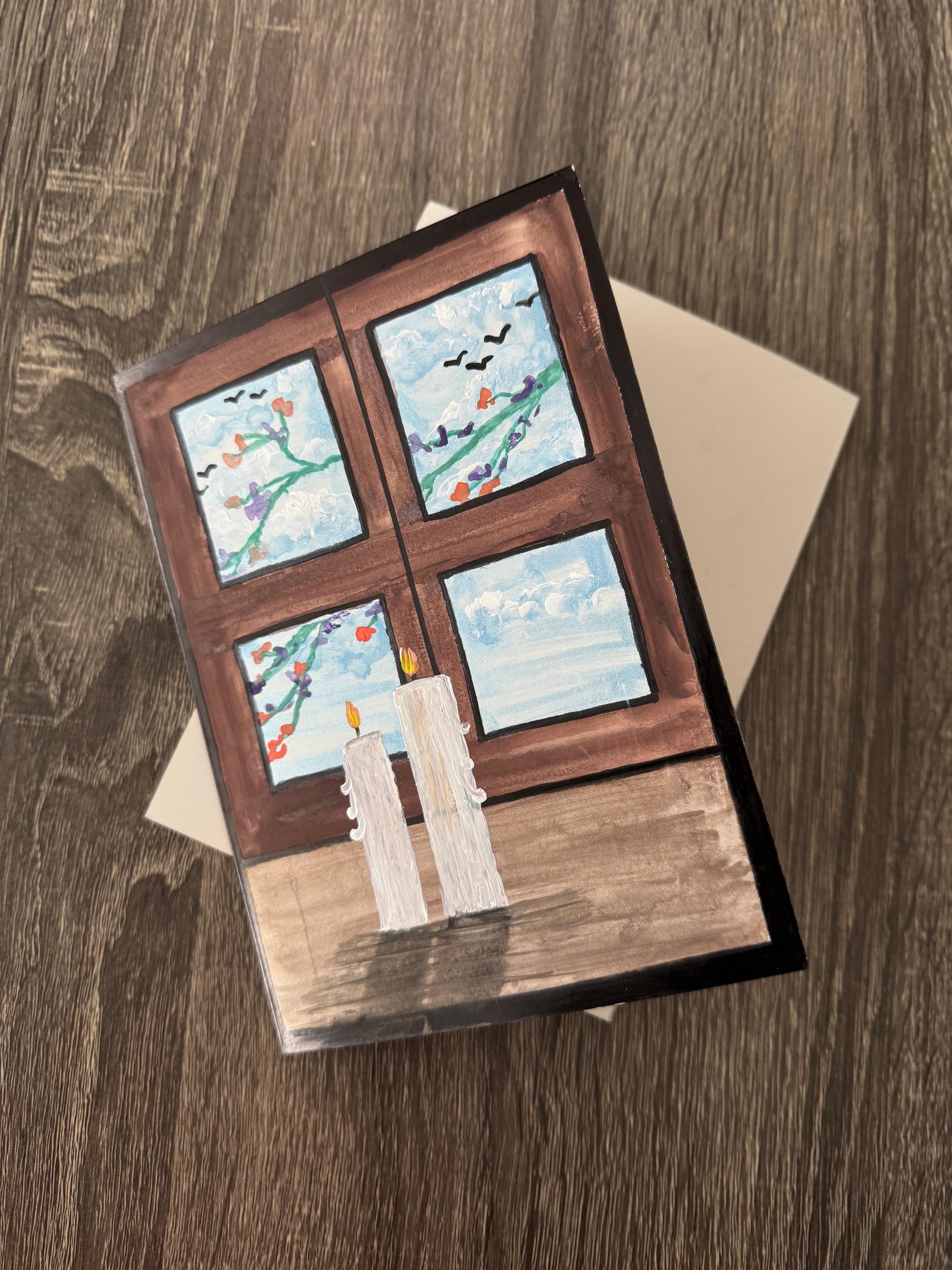 Card with a window design featuring four small scenes .